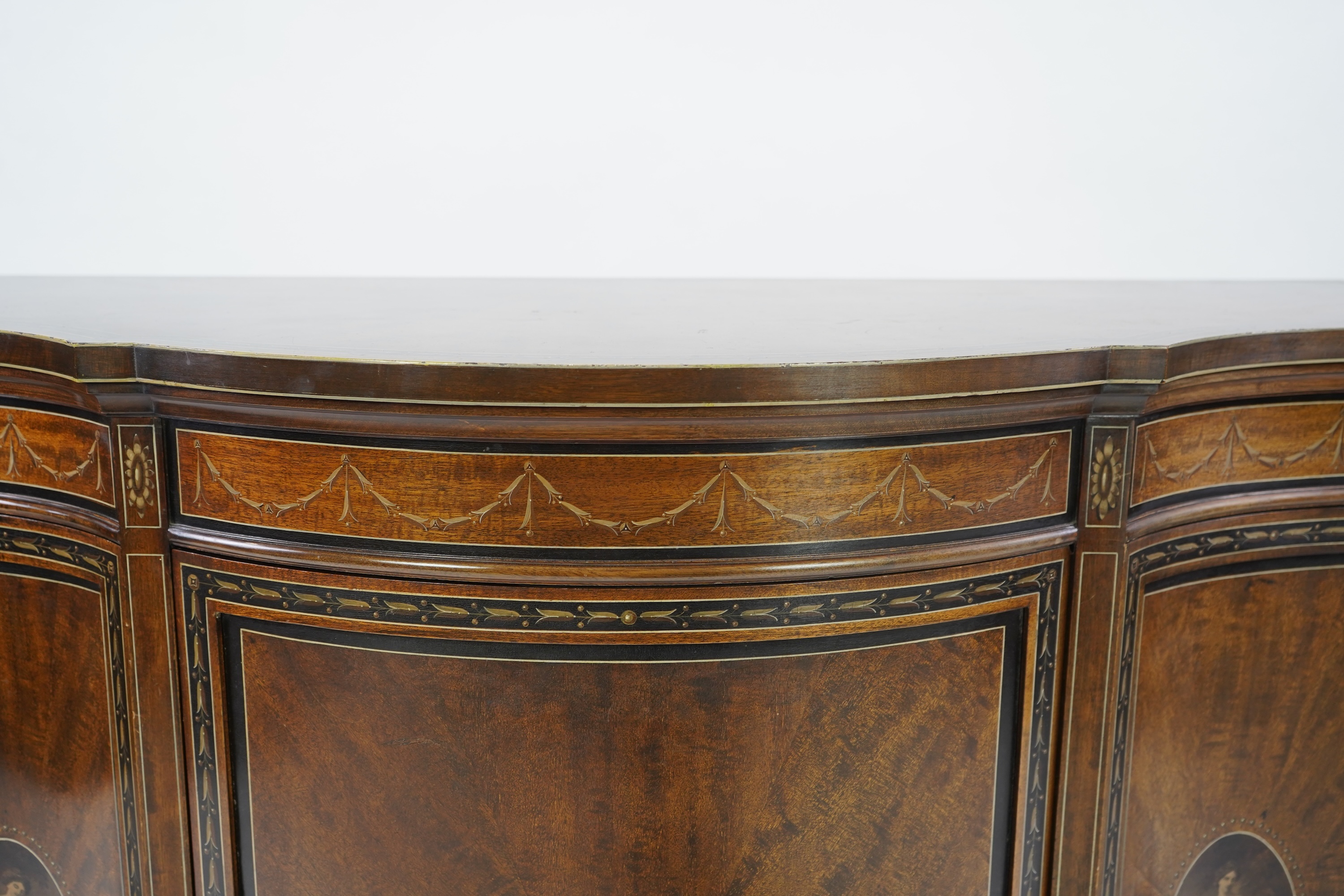 An Edwardian Sheraton Revival painted mahogany bowfront side cabinet
